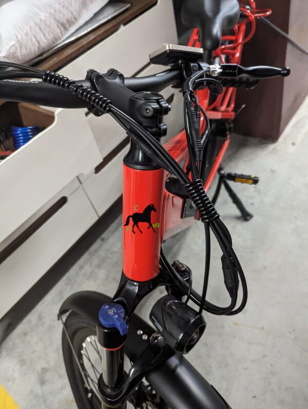 A red and black electric bike with a horse on the back.